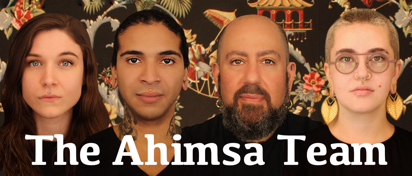 4 Members of the Ahimsa Piercing Studio Team in front of decorative wallpaper with text that reads "The Ahimsa Team"