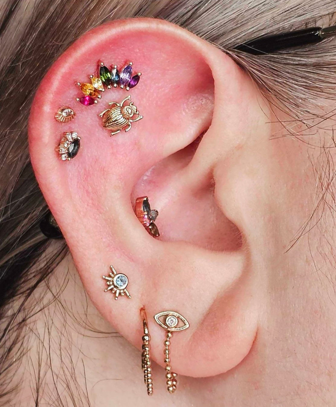 Right ear with multiple piercing. Rainbow colored jewelry collection. Curated ear in rose gold. Jewelry Stud. Rose Gold. Earring. Cartilage Earring. Nostril jewelry. Gold Jewelry. BVLA. Body Vision Los Angeles Jewelry. Brooklyn Piercing Jewelry