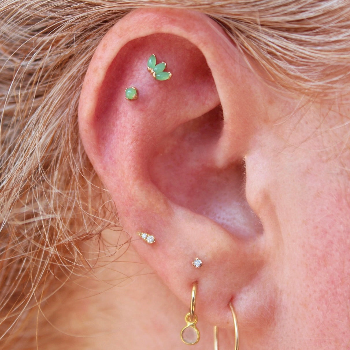 Right ear featuring an assortment of BVLA jewelry in 14k Yellow gold with Chrysoprase and Diamonds, pieces include a "Jeanie 2", "cab Prong" and a "Marquise Fan"