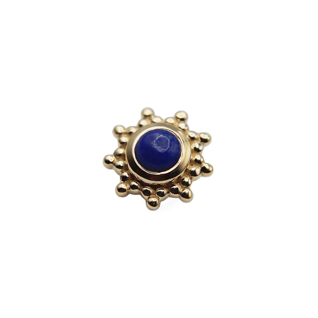 Gold sun-shaped stud with a central lapis gemstone on a white background