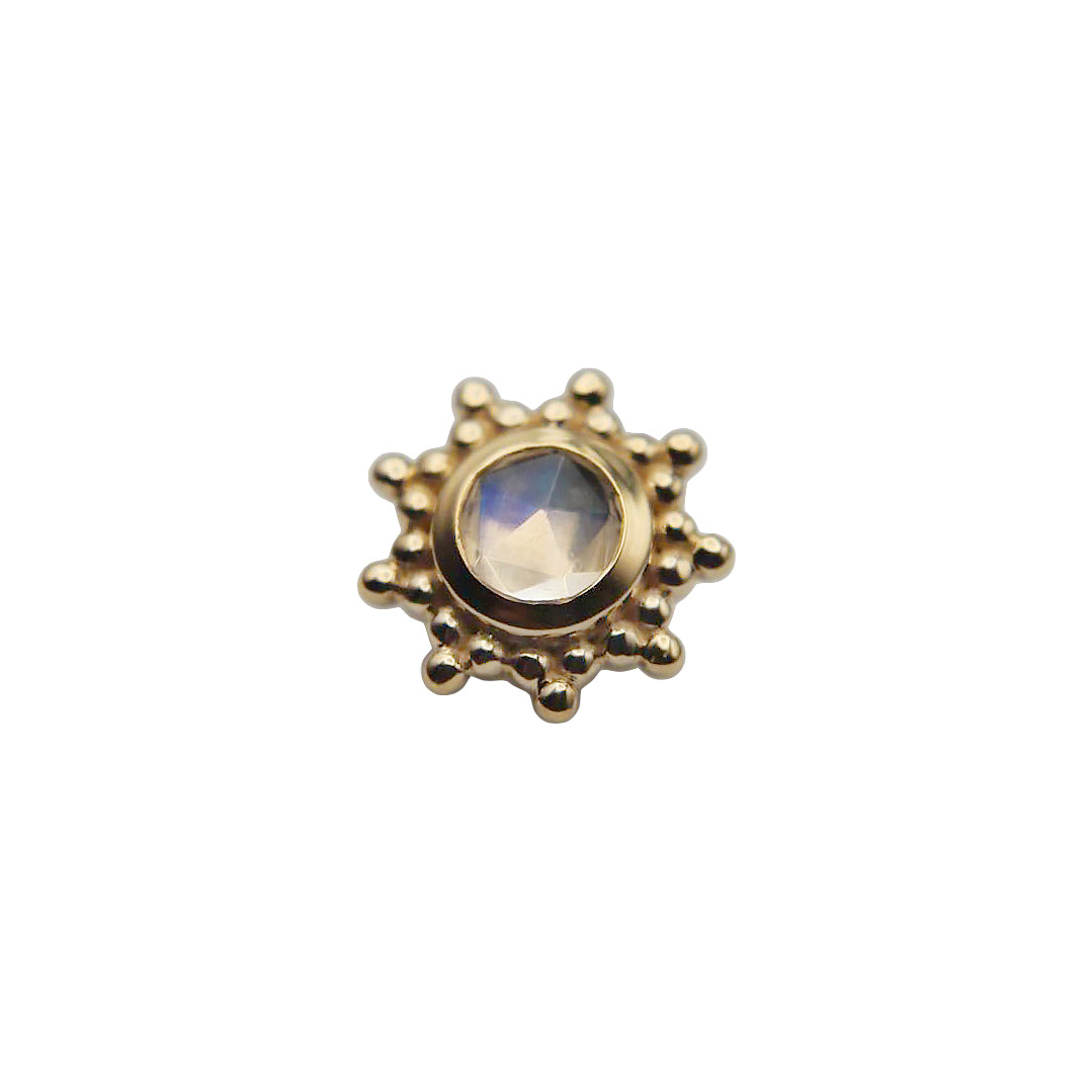 Gold sun-shaped stud with a central rainbow moonstone gemstone on a white background