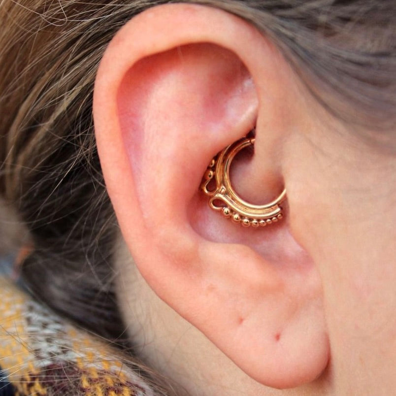 
                  
                    Right ear with BVLA's "Adele" in 14k Yellow gold in a daith piercing
                  
                