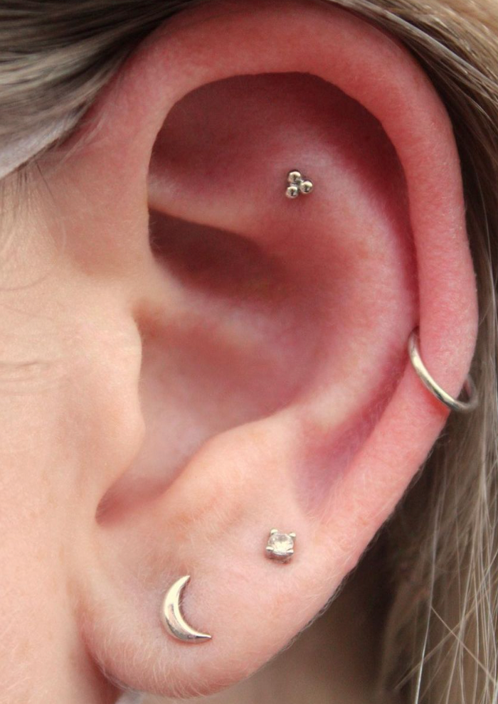 Left ear featuring a 14k White gold BVLA "Tri Bead Cluster" in a flat piercing along with an assortment of other gold jewelry