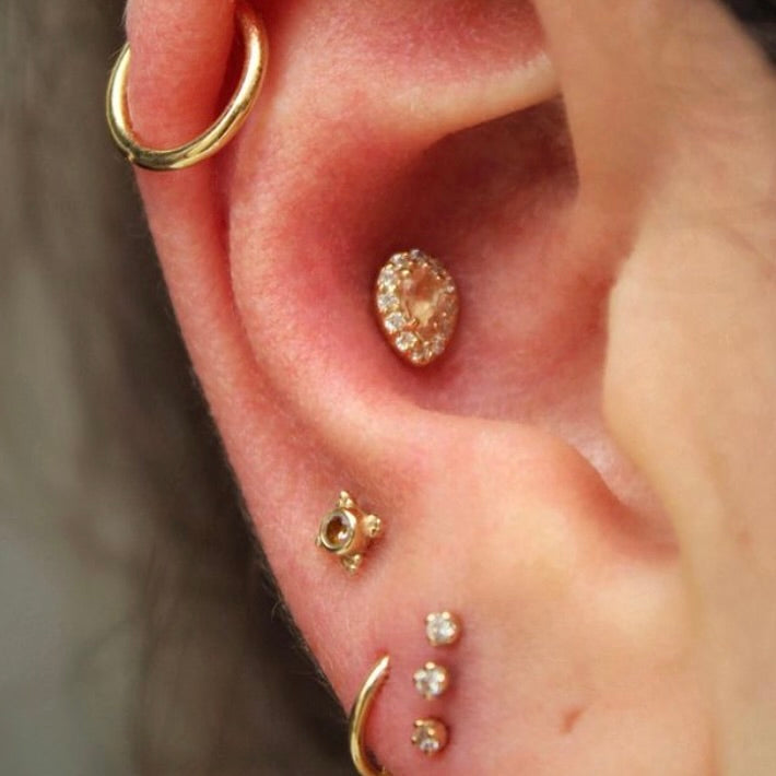 Right ear with an assortment of BVLA jewelry in 14k Yellow gold with CZ and Oregon Sunstone as well as two fitted 14k Yellow gold hoops